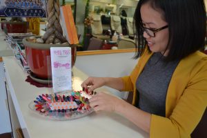 A worker at Nail Trix helps customers pick out colors for gel nails.